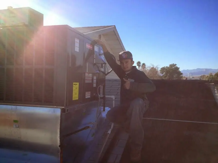 HVAC technician performing Air Duct Cleaning on a rooftop unit in Albany